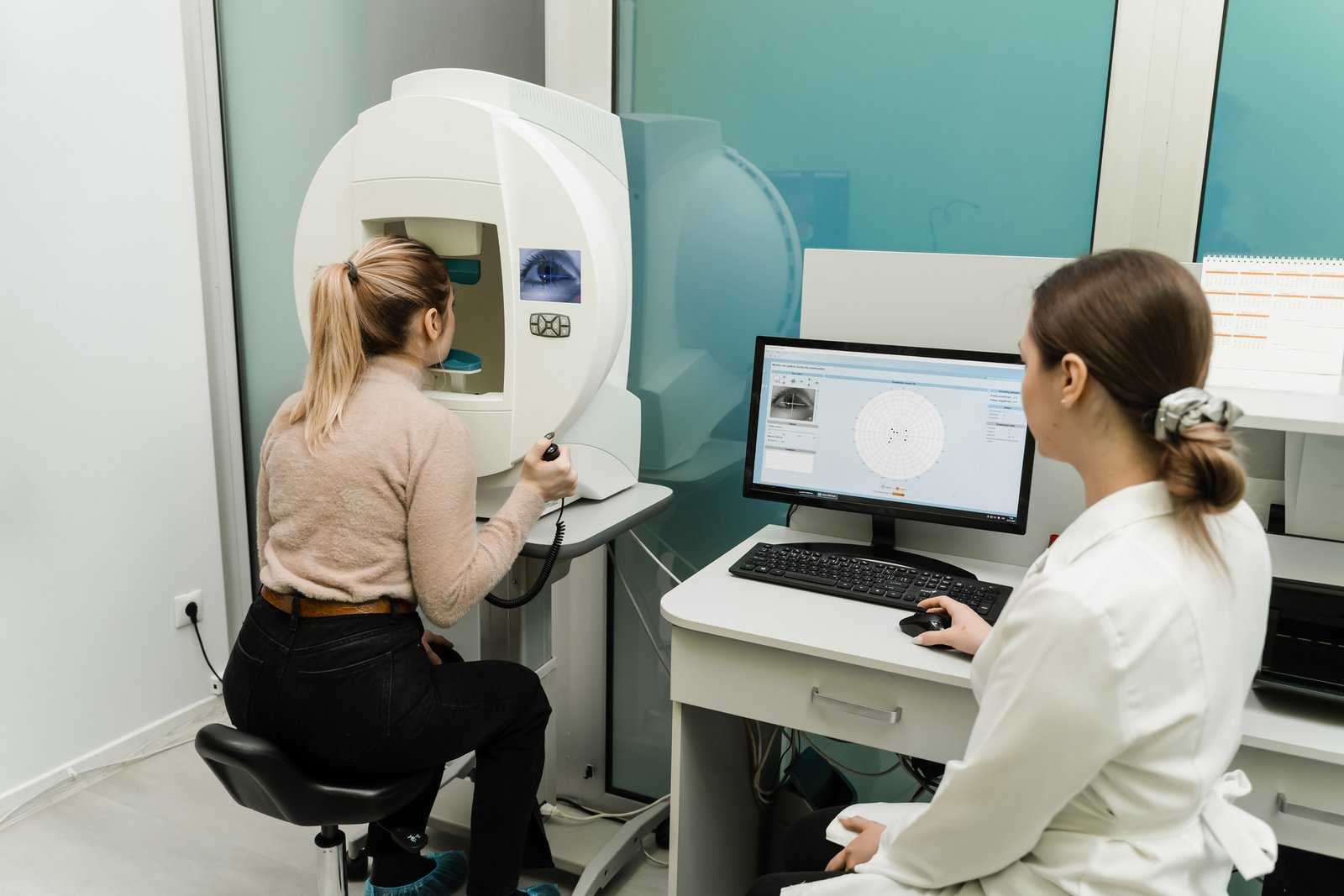 pole-ophtalmologie-colombes-la-defense orthoptiste faisant passer un examen du champ visuel de Humphrey à une patiente