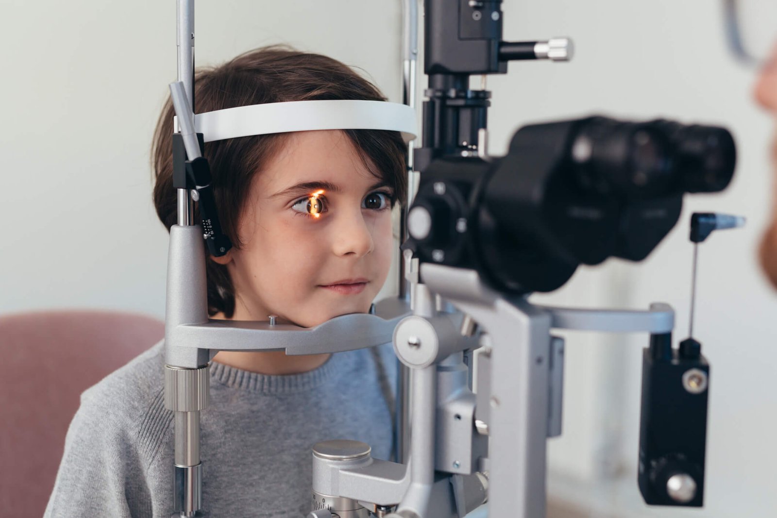 pole-ophtalmologie-colombes-la-defense enfant devant un appareil optique au cours d'une consultation d'ophtalmo-pédiatrie