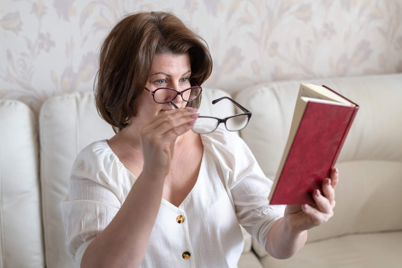 astigmatisme-colombes femme souffrant de presbytie utilisant des lunettes pour lire un livre